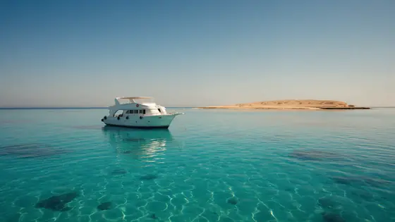 يخت على مياه البحر الأحمر الفيروزية قرب جزيرة في الغردقة